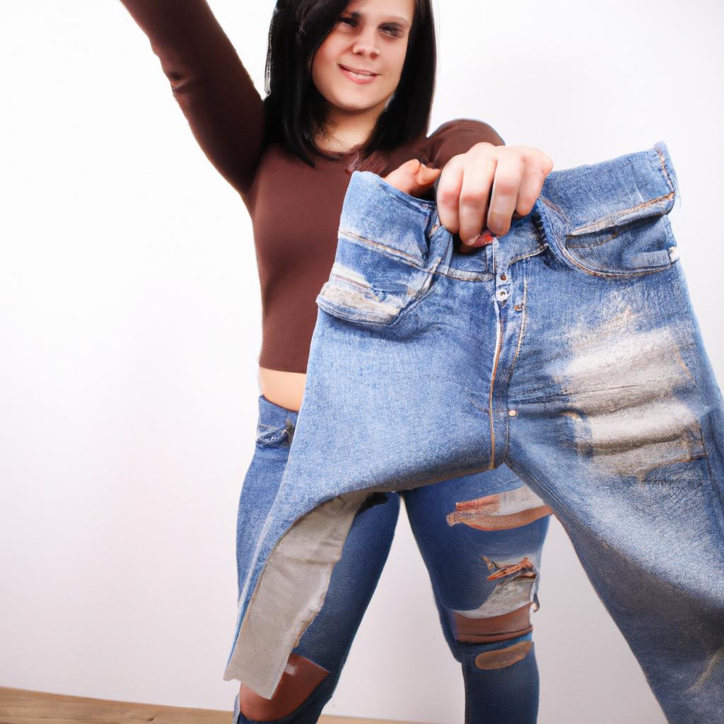 Person holding up jeans, smiling
